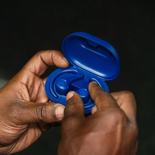 Hands opening the blue JBuds Sport ANC 4 charging case