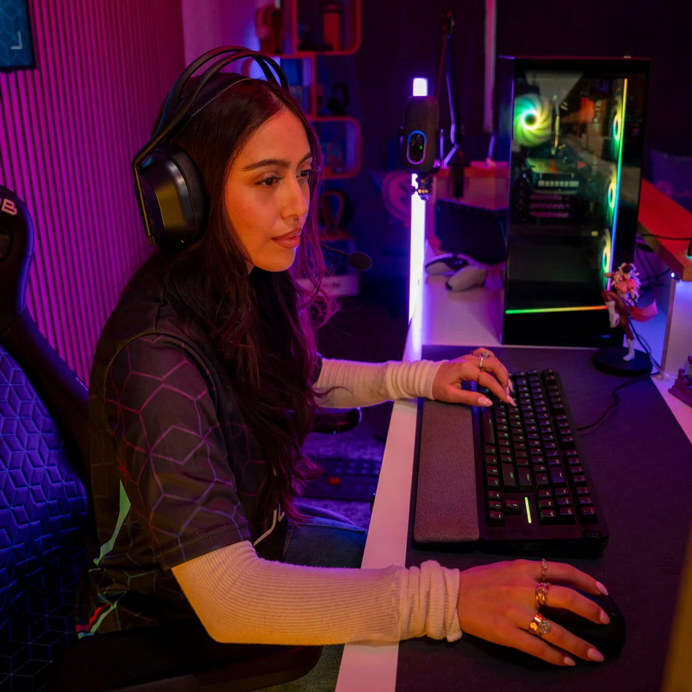A gamer wearing the Daybreak headset, one hand on the Daybreak keyboard and the other on the Daybreak mouse